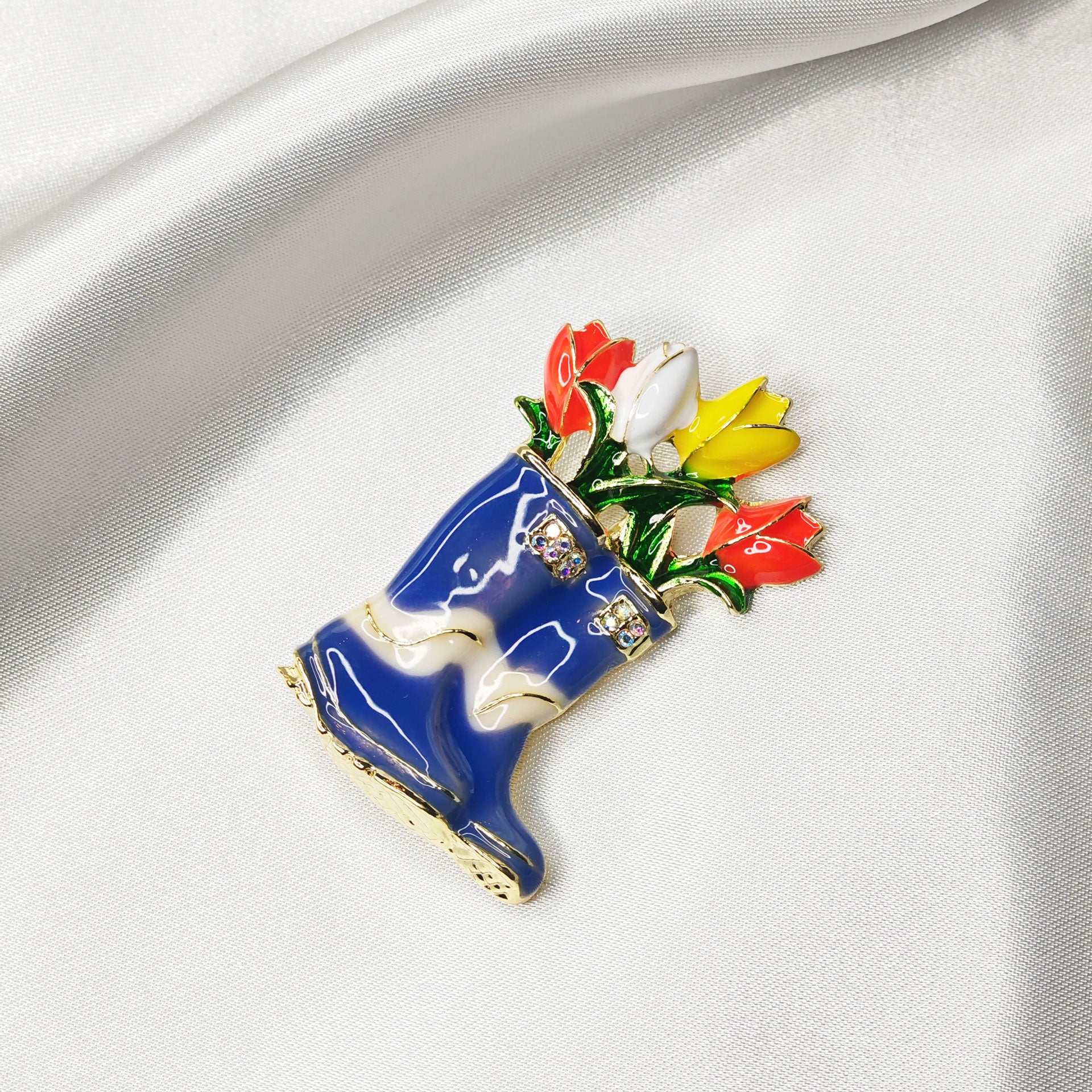 Broche bijou bottes de pluie bleues avec fleurs multicolores vue isométrique