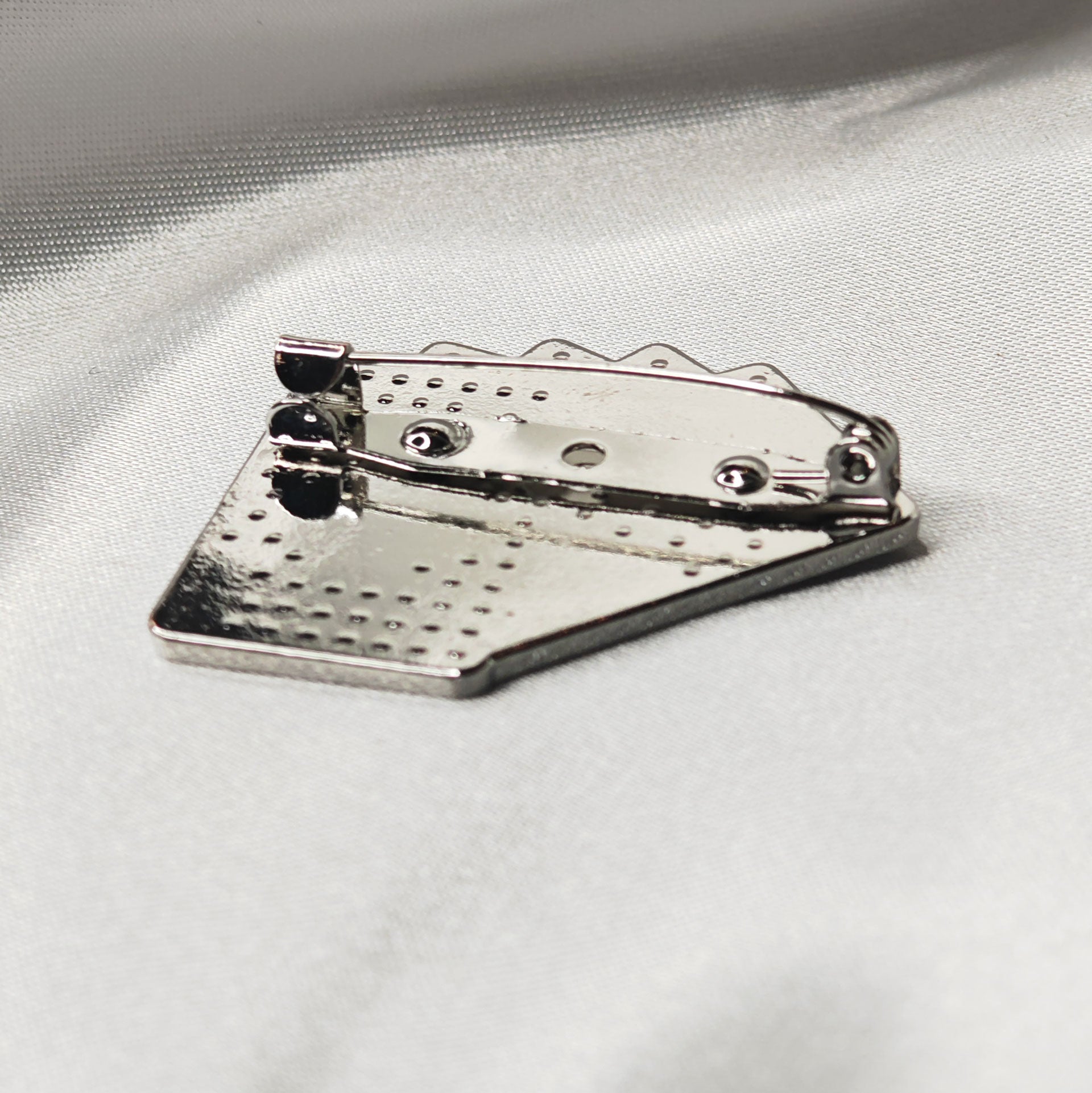 Dos de la broche poker argentée avec attache épingle et finition métallique brillante