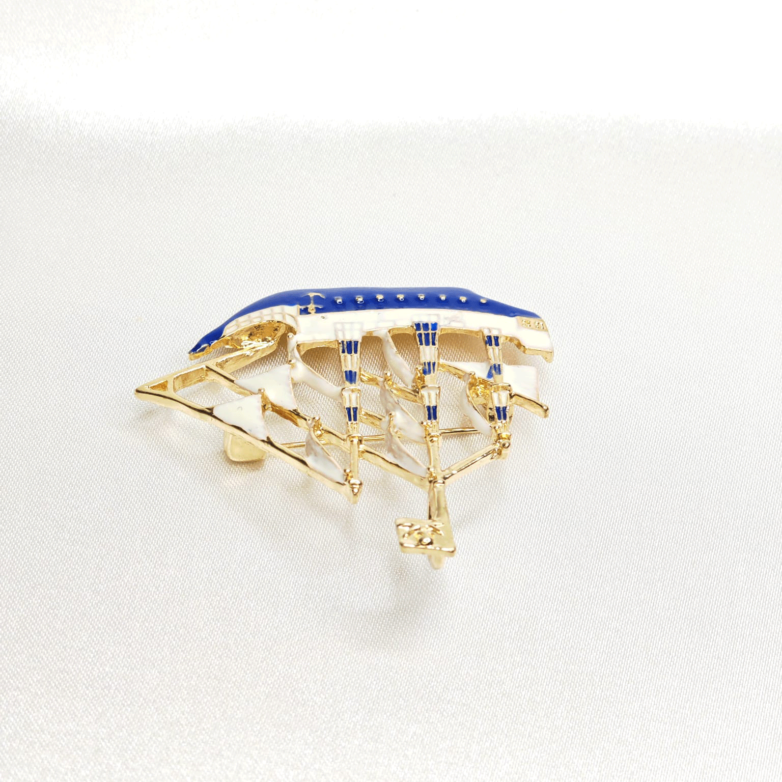 Goldene blaue und weiße Bootsbrosche