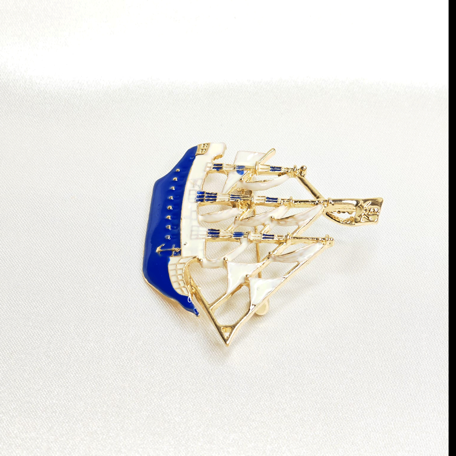 Goldene blaue und weiße Bootsbrosche
