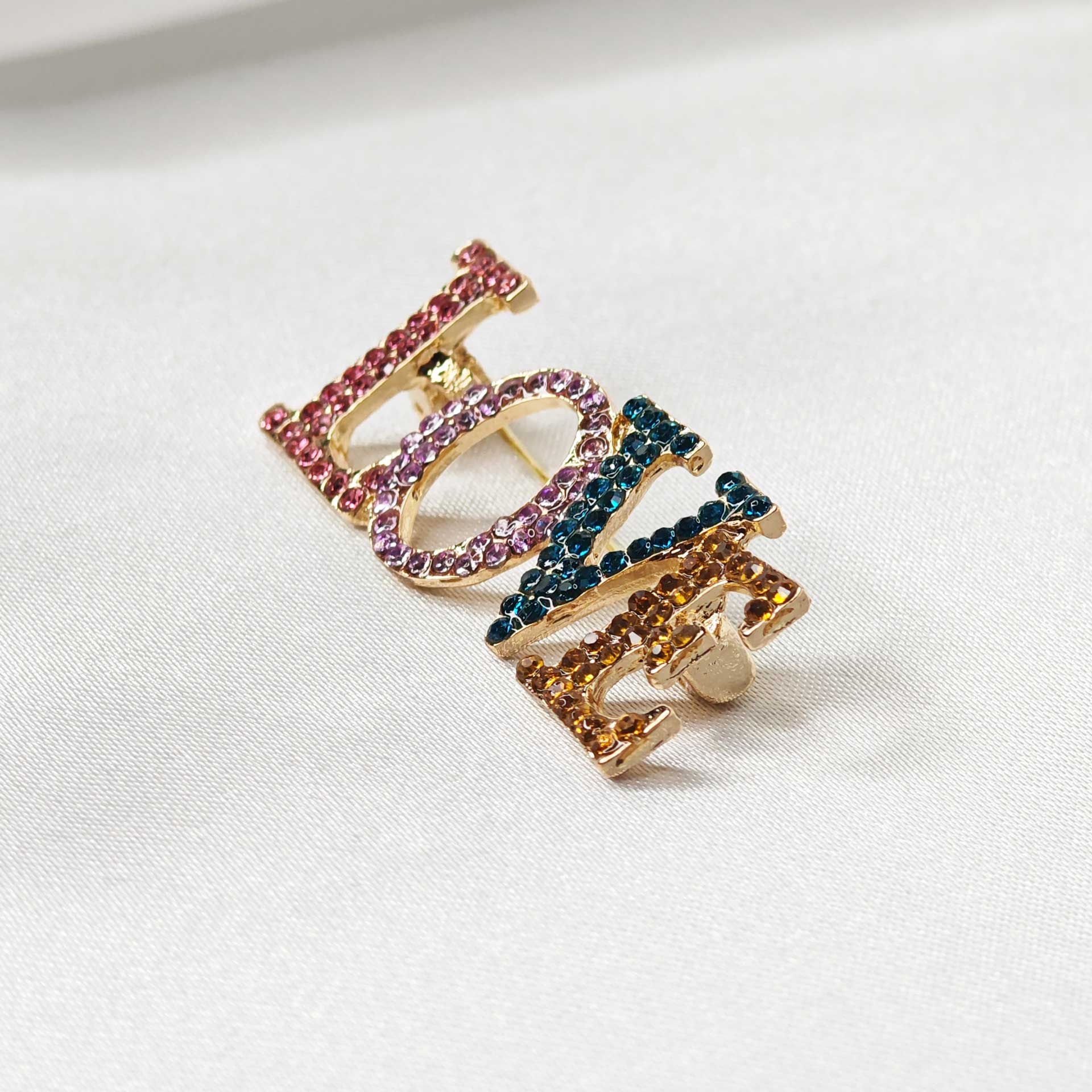 Photo latérale droit de la broche LOVE en écriture capitale et multicolore.