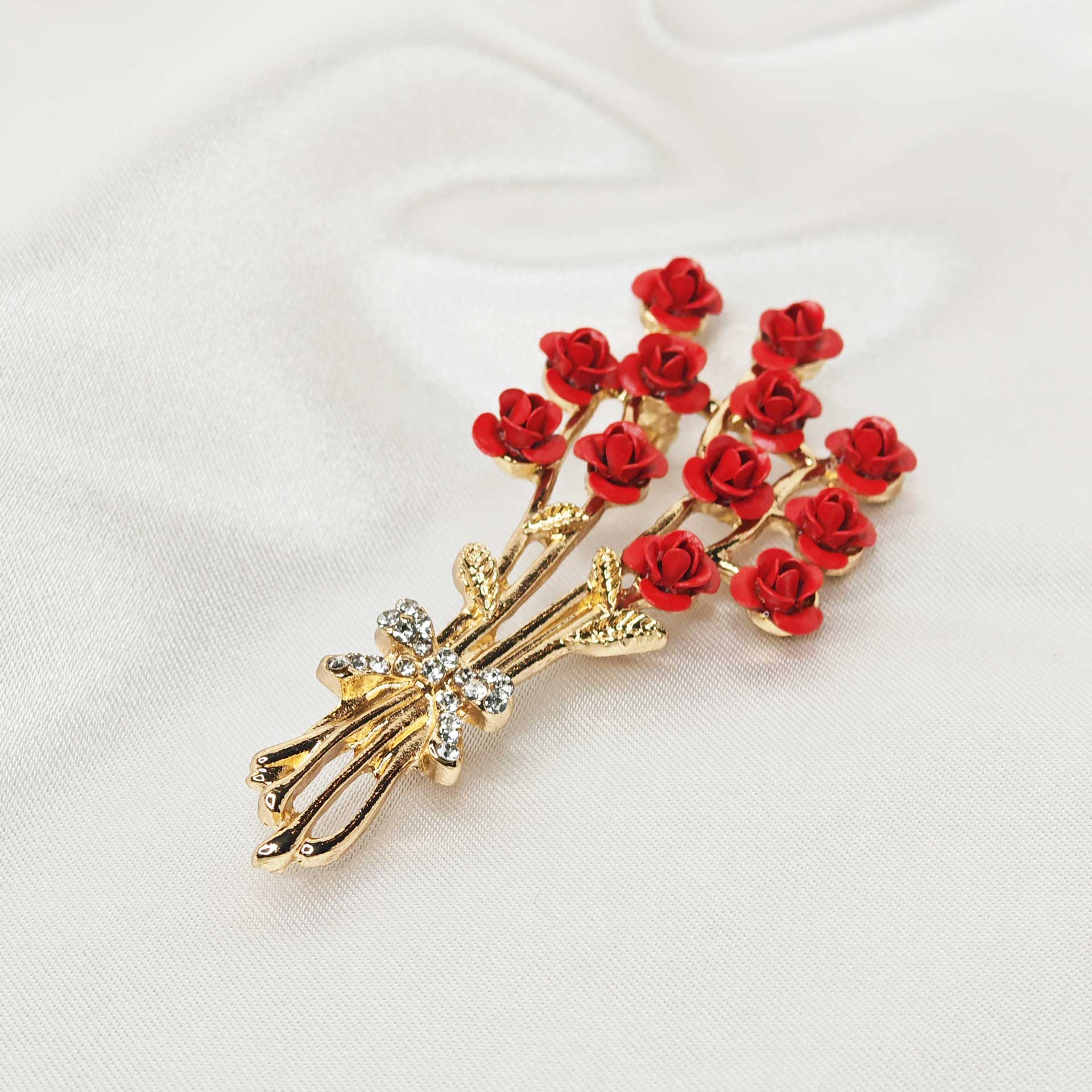 Photo de la broche bouquet de rose rouge avec vue sur le noeud enveloppant les tiges.