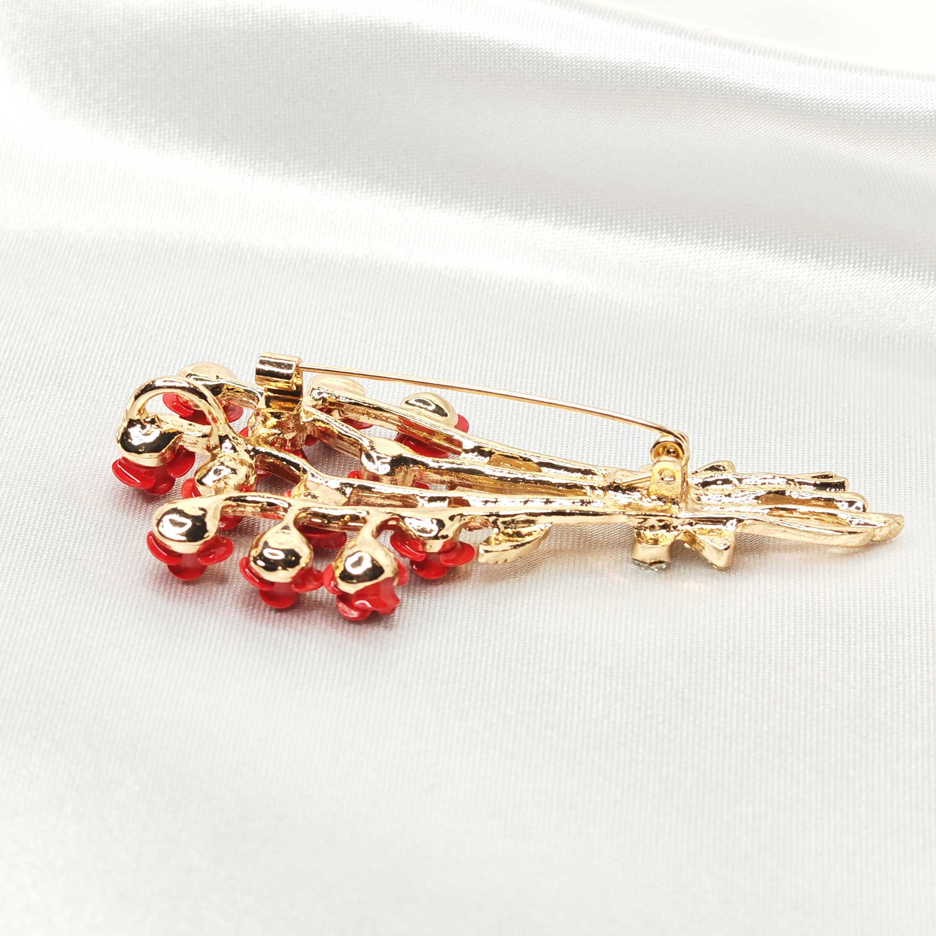 vue du dos de la broche bouquet de rose rouge, mettant en valeur l'attache épingle à nourrice.