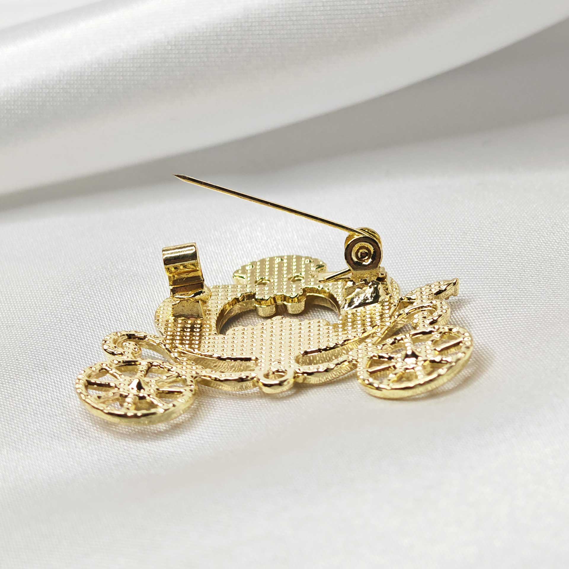 Mise en avant de l'attache épingle à nourrice de la broche carrosse