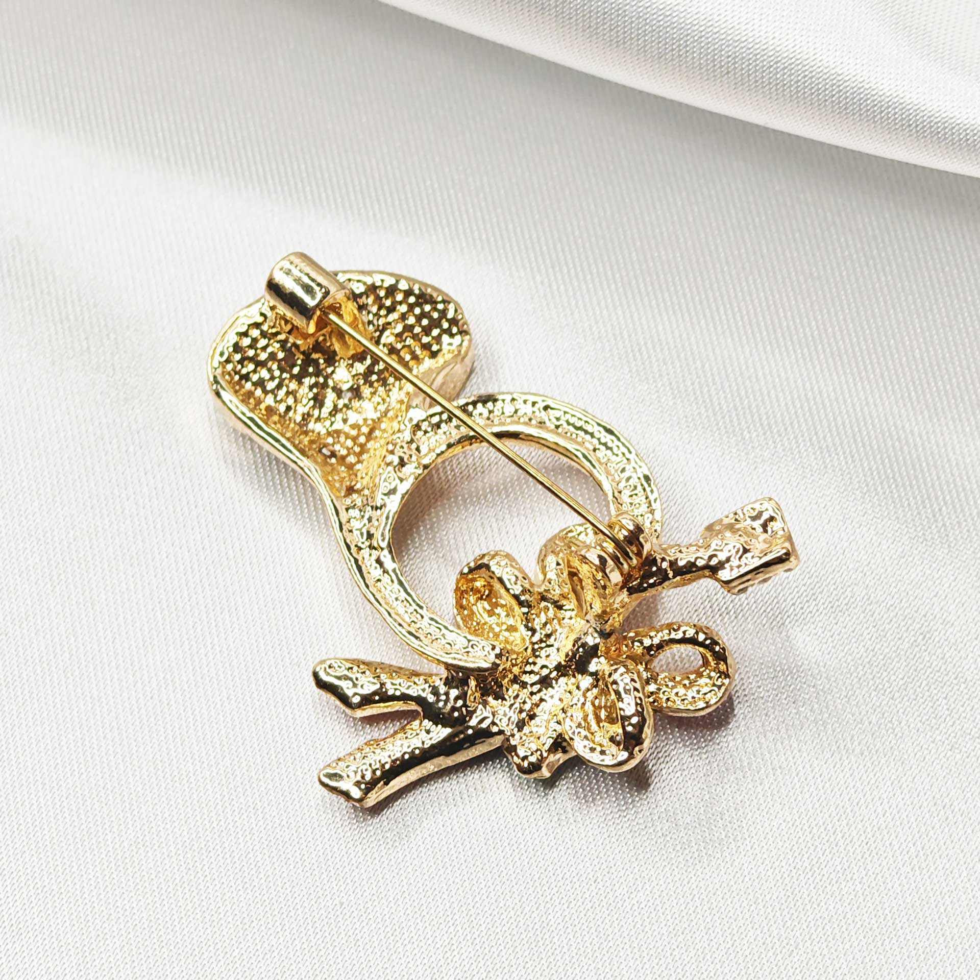 vue de dessus du dos de la broche cor de chasse avec l'épingle à nourrice fermée