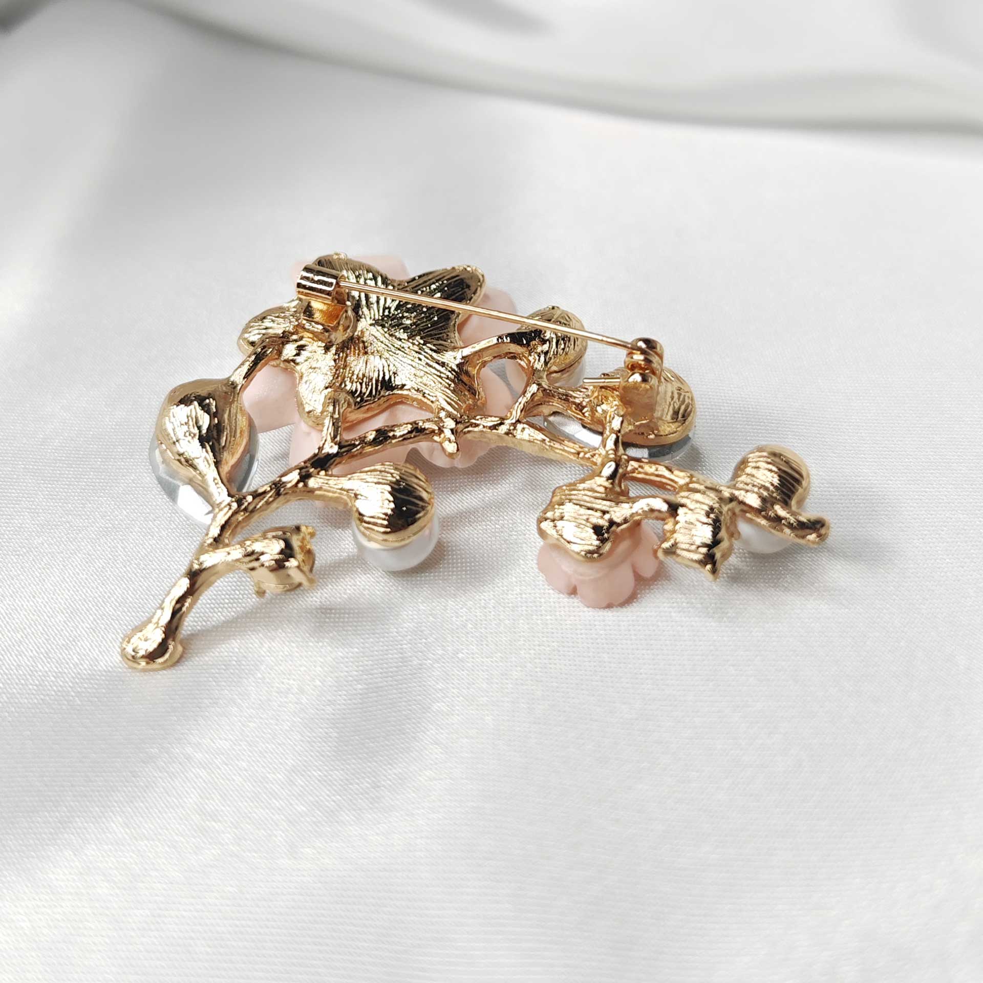 Photo du verso de la broche fleur de cerisier sakura rose ornée de perles et de cristaux blancs