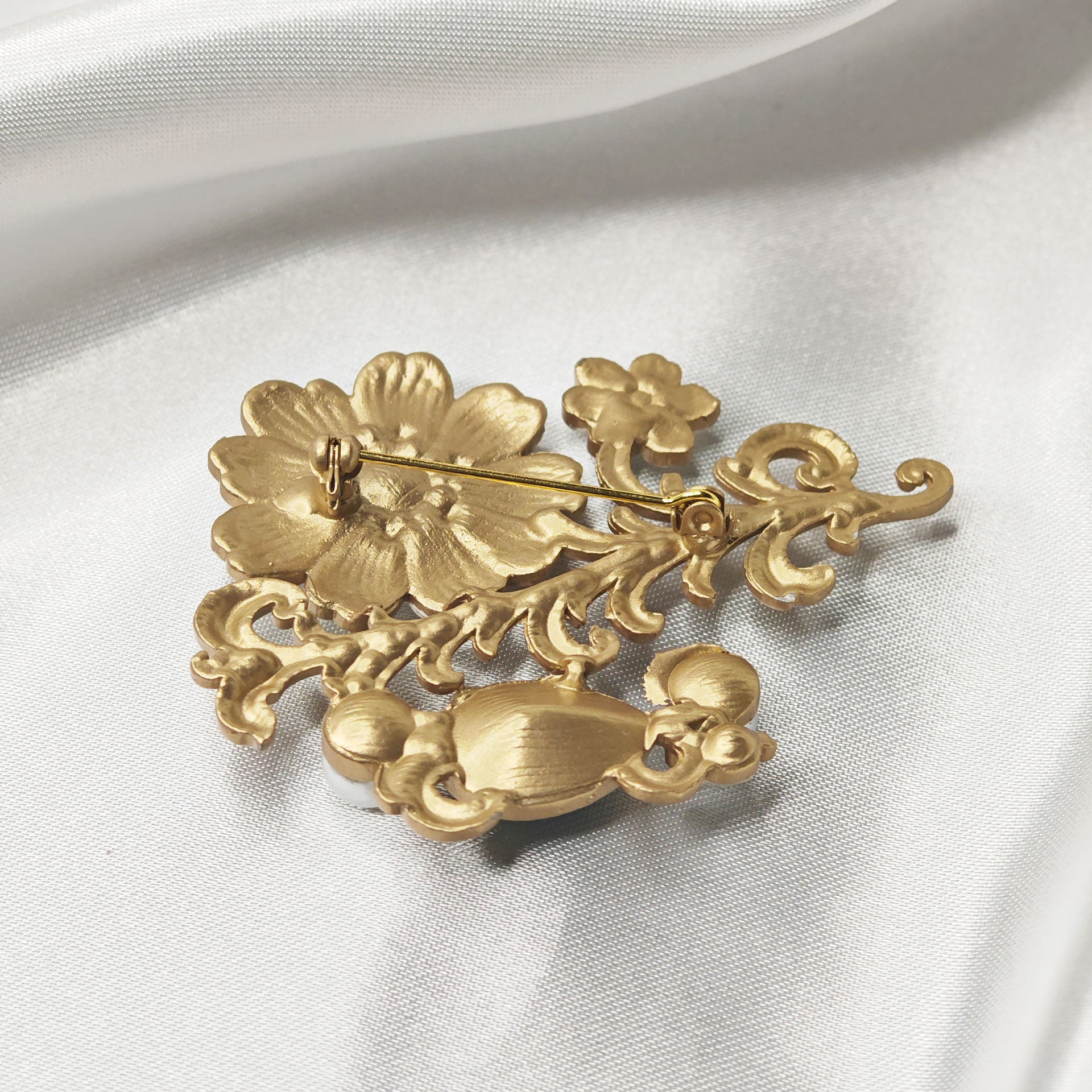 Dos de la broche fleur baroque dorée avec attache épingle de sécurité, finition métal doré