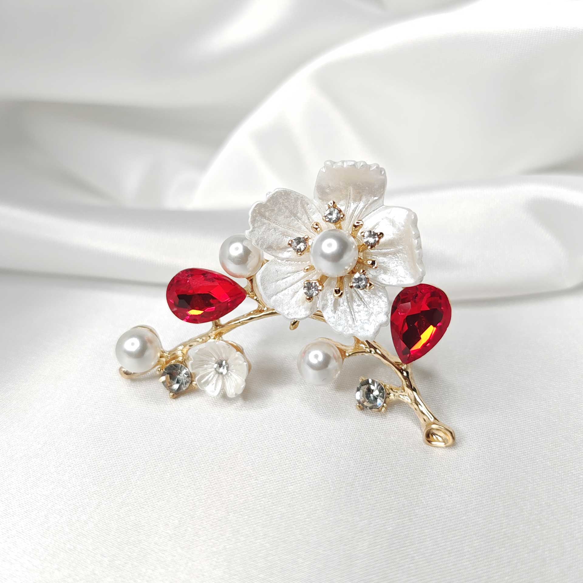 Photo 1 de la Broche fleur de cerisier Sakura sur une branche dorée ornée de perles et cristaux rouges