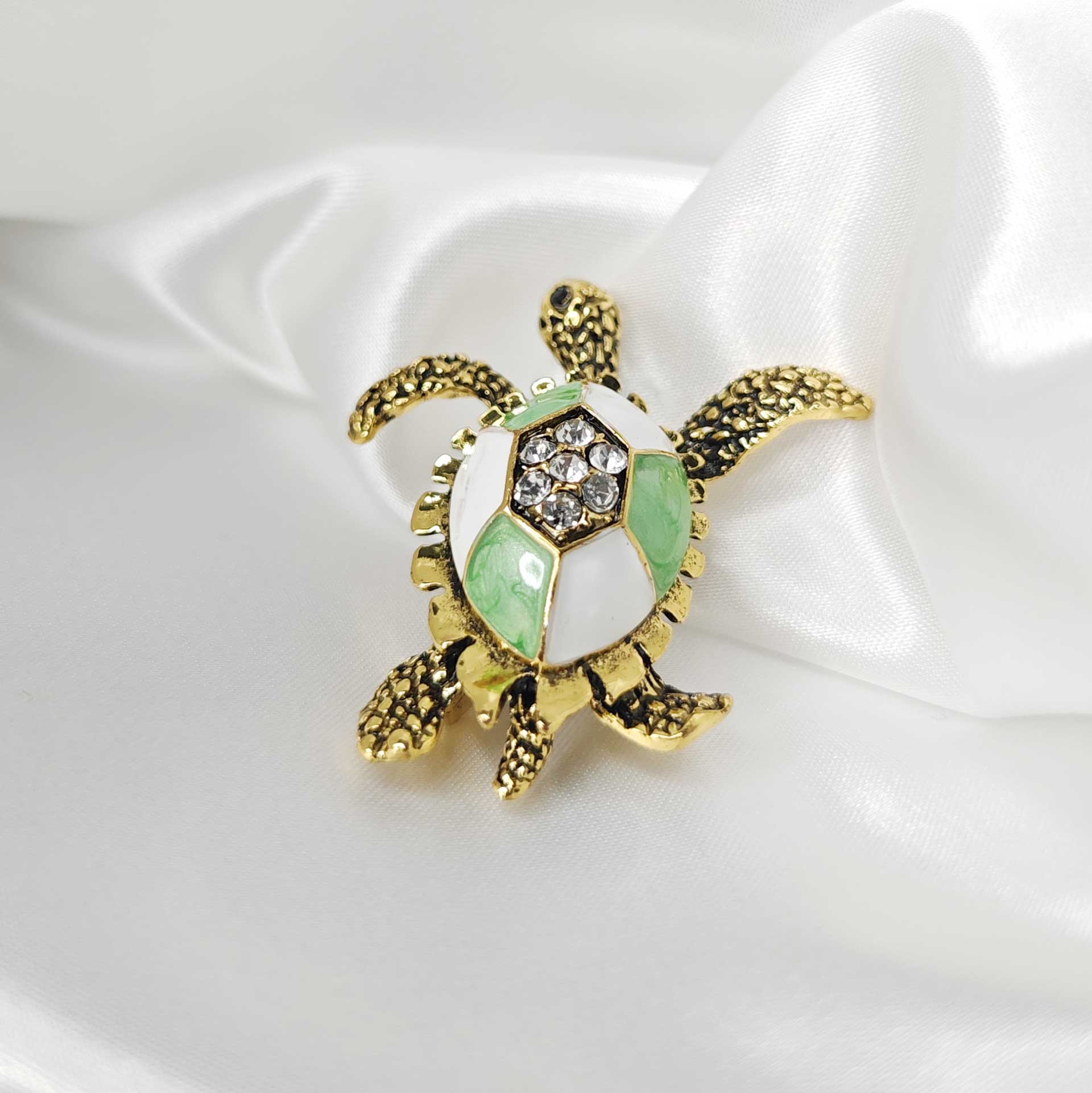 Photo 4 de la broche tortue de mer finition vintage avec une carapace blanche et verte.