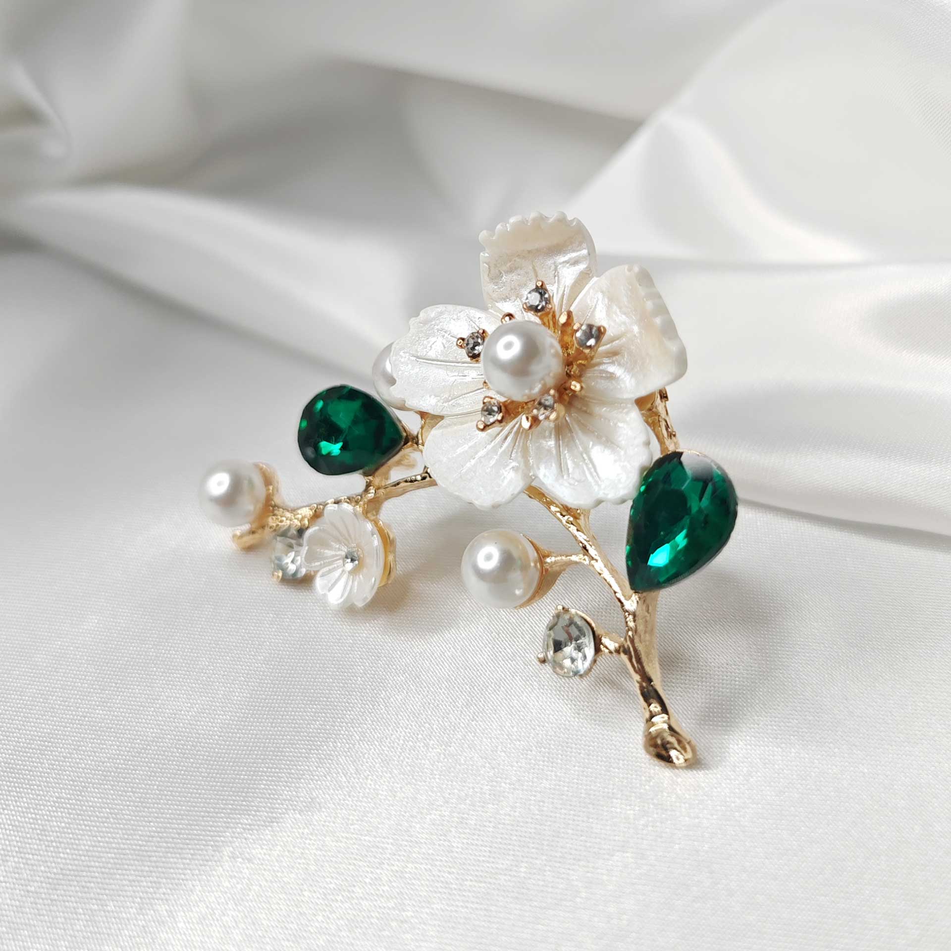 Photo 2 de la Broche fleur de cerisier sakura sur branche ornée de perles et cristaux verts.