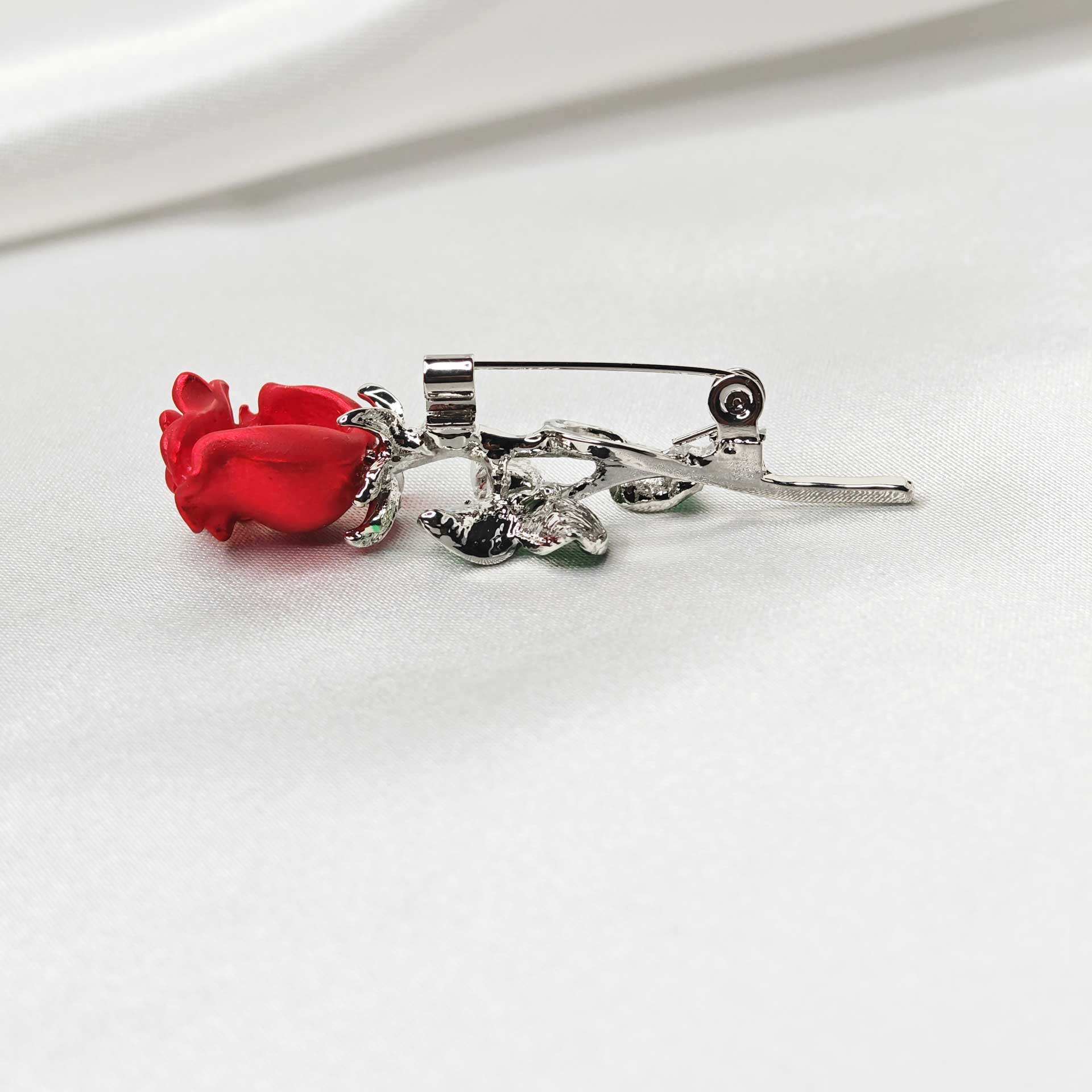 Photo vue zoom sur l'épingle à nourrice en position fermée de la broche rose rouge