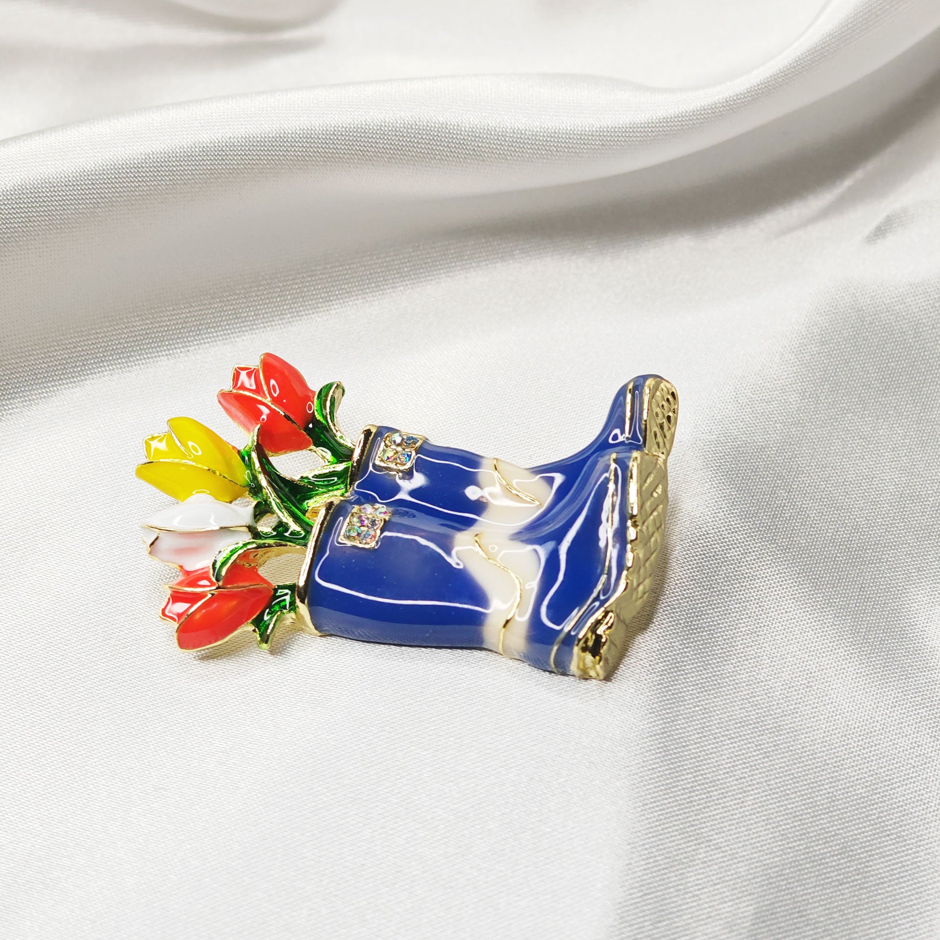 Broche bijou bottes de pluie bleues avec fleurs multicolores vue isométrique