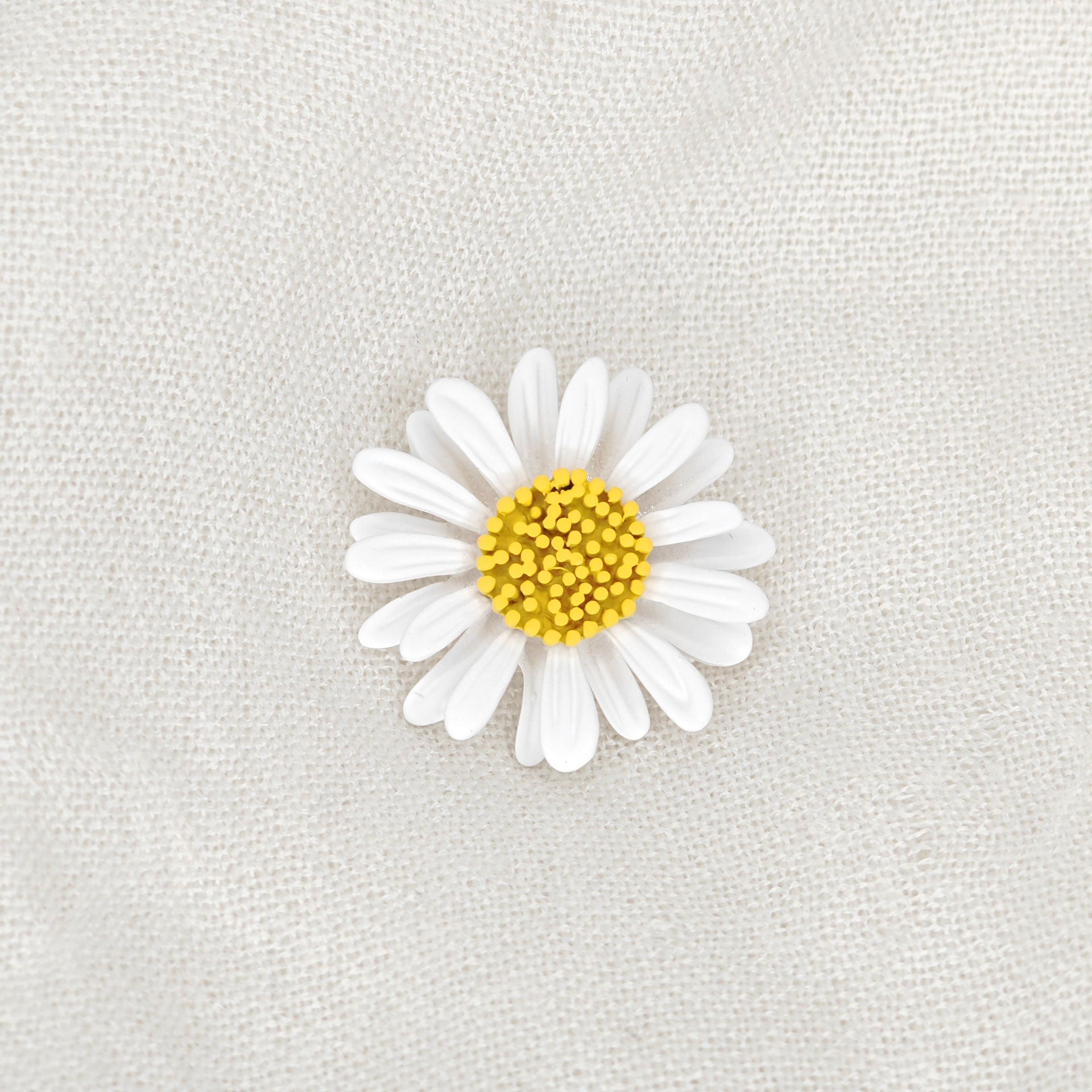 Broche florale en forme de marguerite blanche avec un cœur jaune