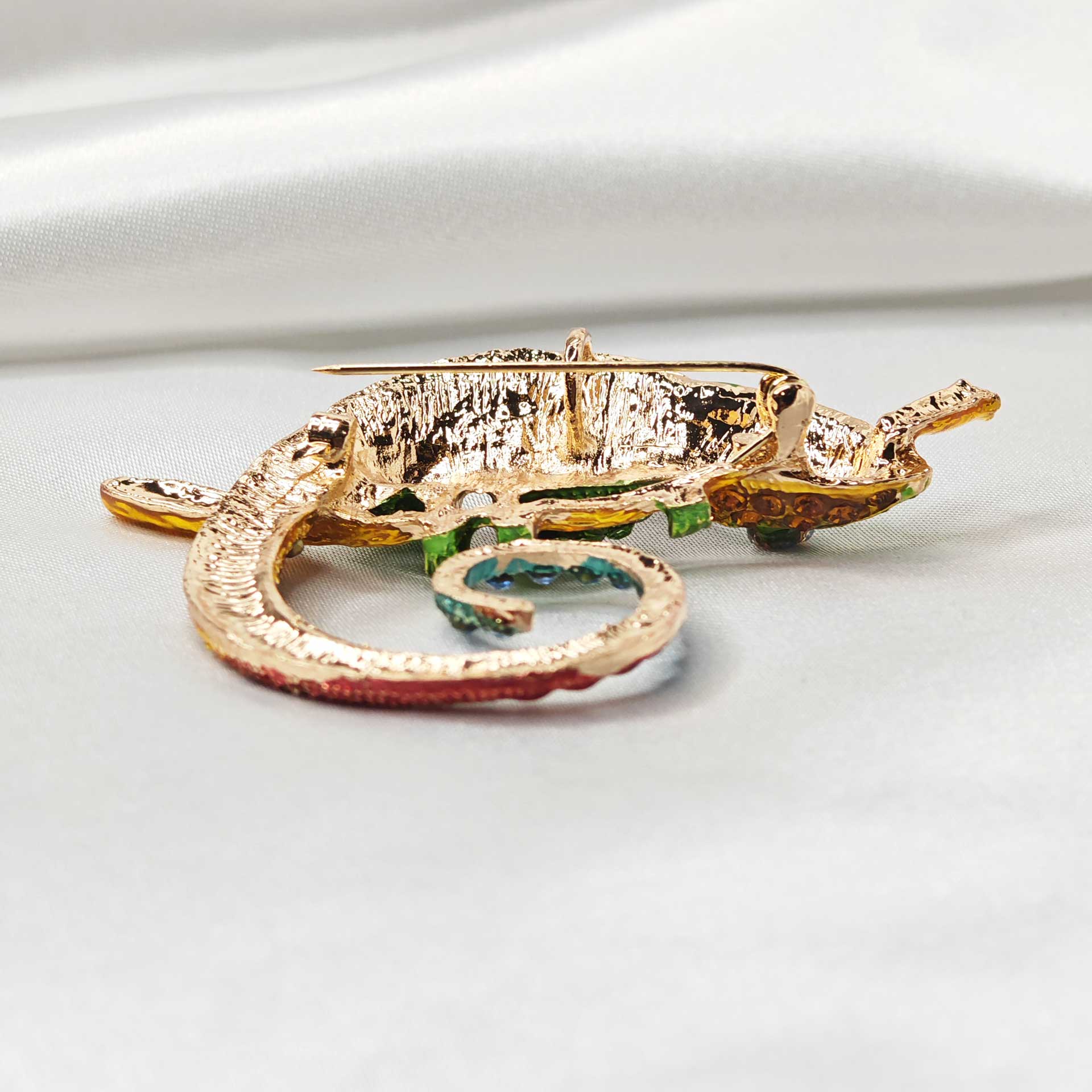 Photo zoom sur l'attache de la broche bijou caméléon multicolore.