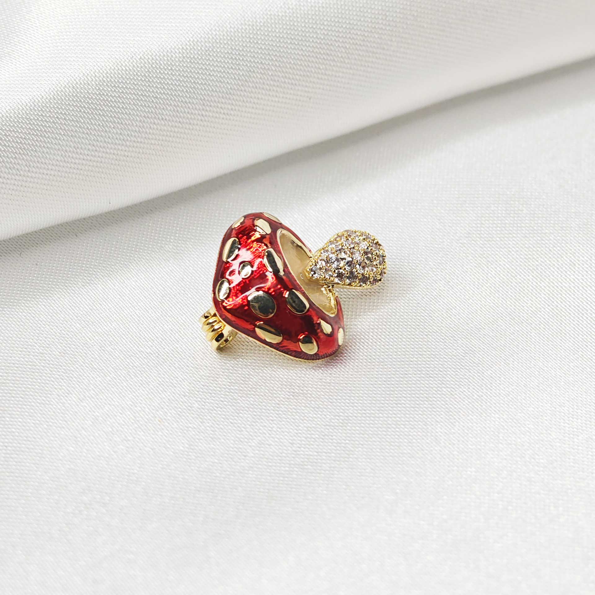 Photo vue latérale de la broche champignon rouge à pois blancs dorés