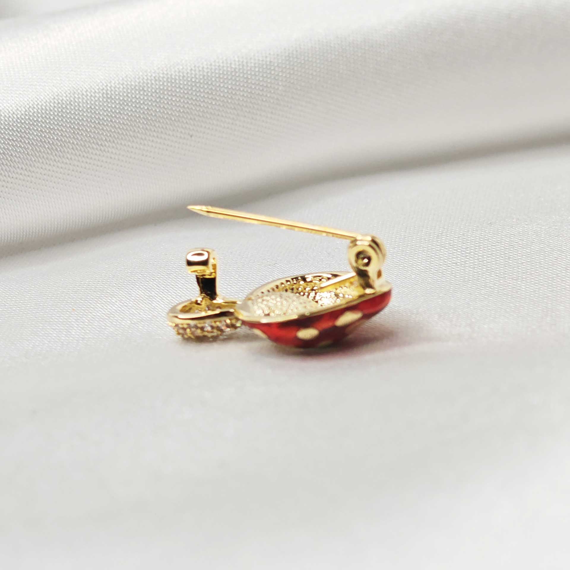 mise en avant de l'attache épingle à nourrice de la broche champignon rouge