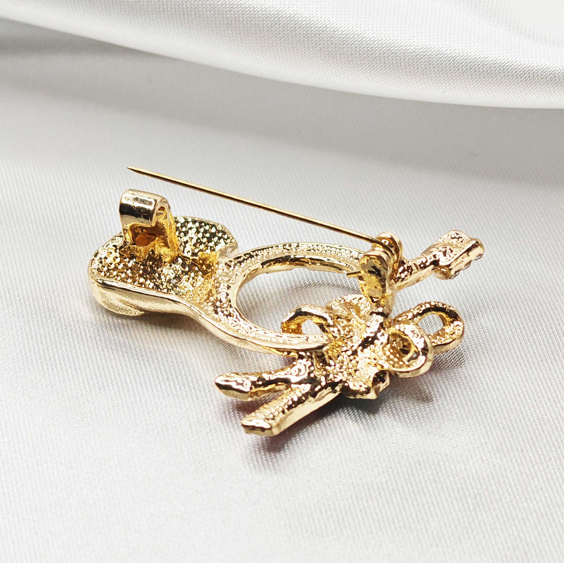 vue zoom sur l'attache épingle à nourrice de la broche cor de chasse