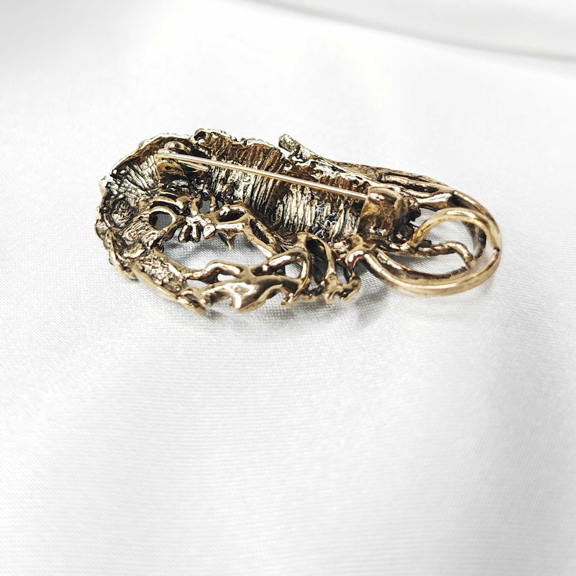 Broche crevette bleue photographiée de dos, montrant la fixation métallique et la qualité de l’attache.