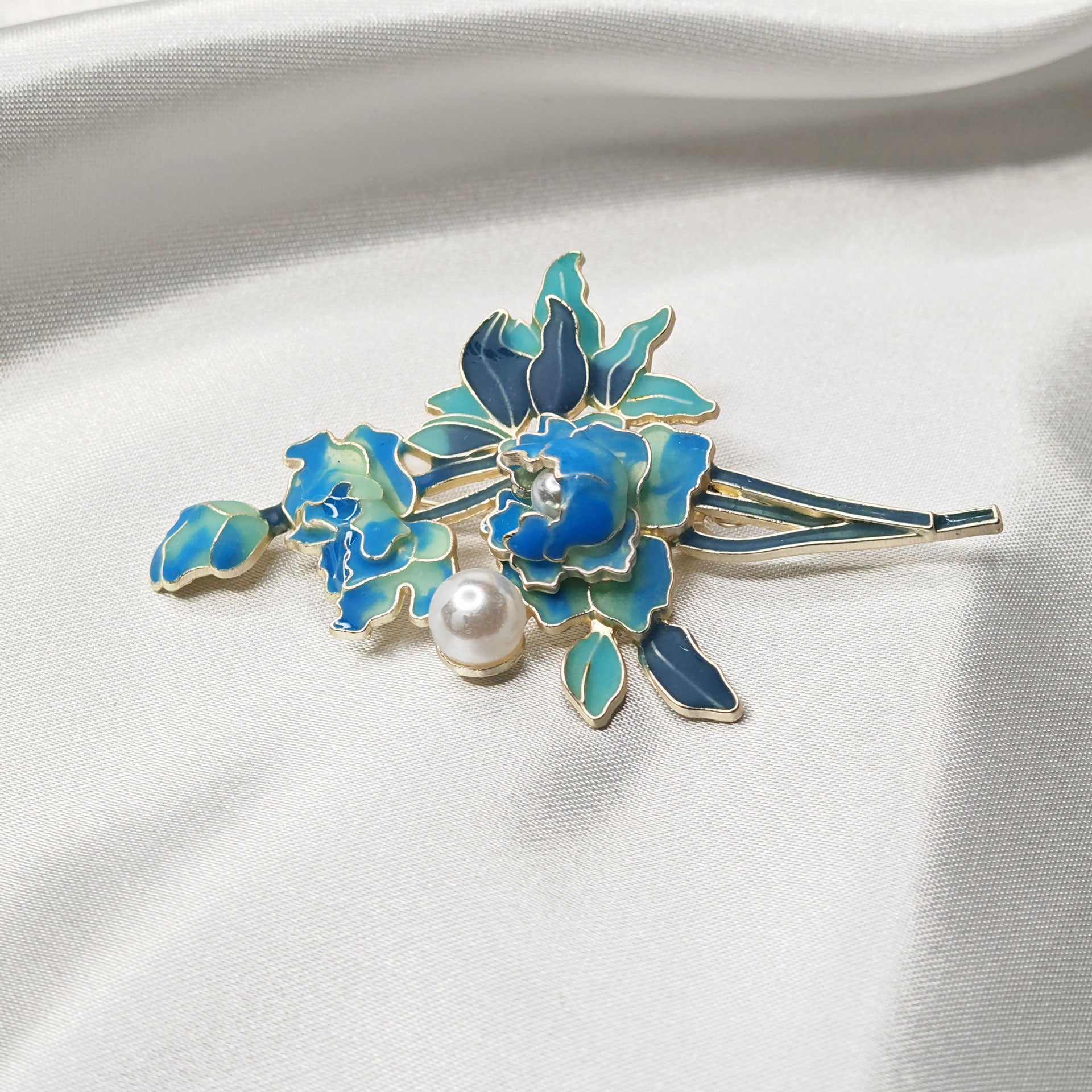 Détail broche bijou pivoine bleue émaillée et perle, finition dorée raffinée