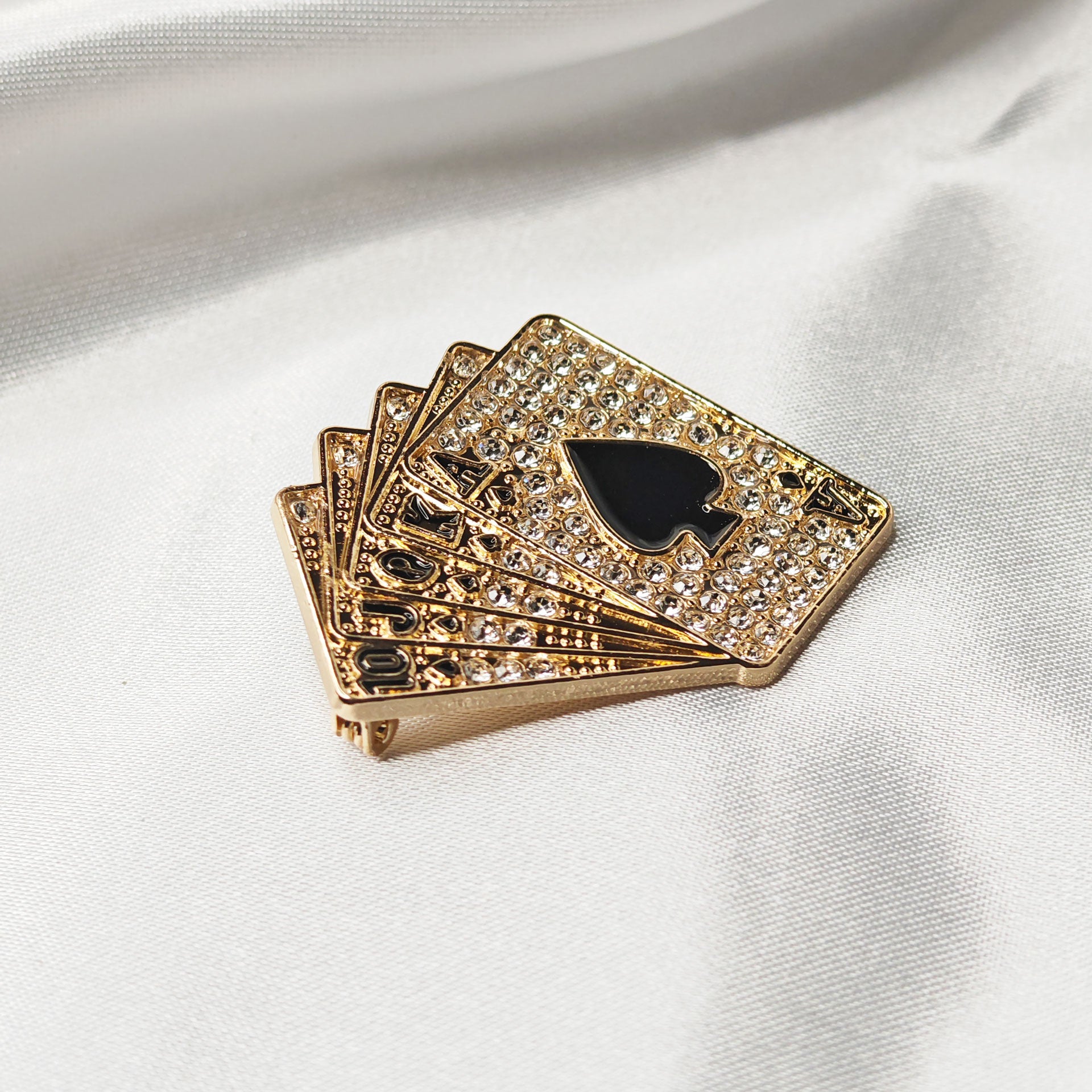 Broche poker luxe dorée strass vue en perspective avec as de pique noir