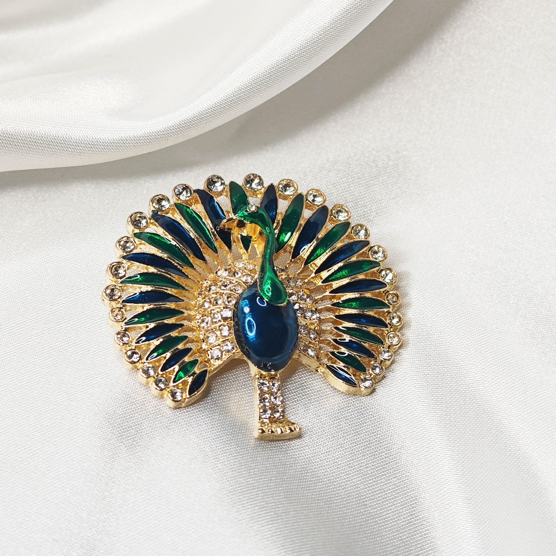 Broche paon élégante dorée bleu vert avec strass vue  de dessus.