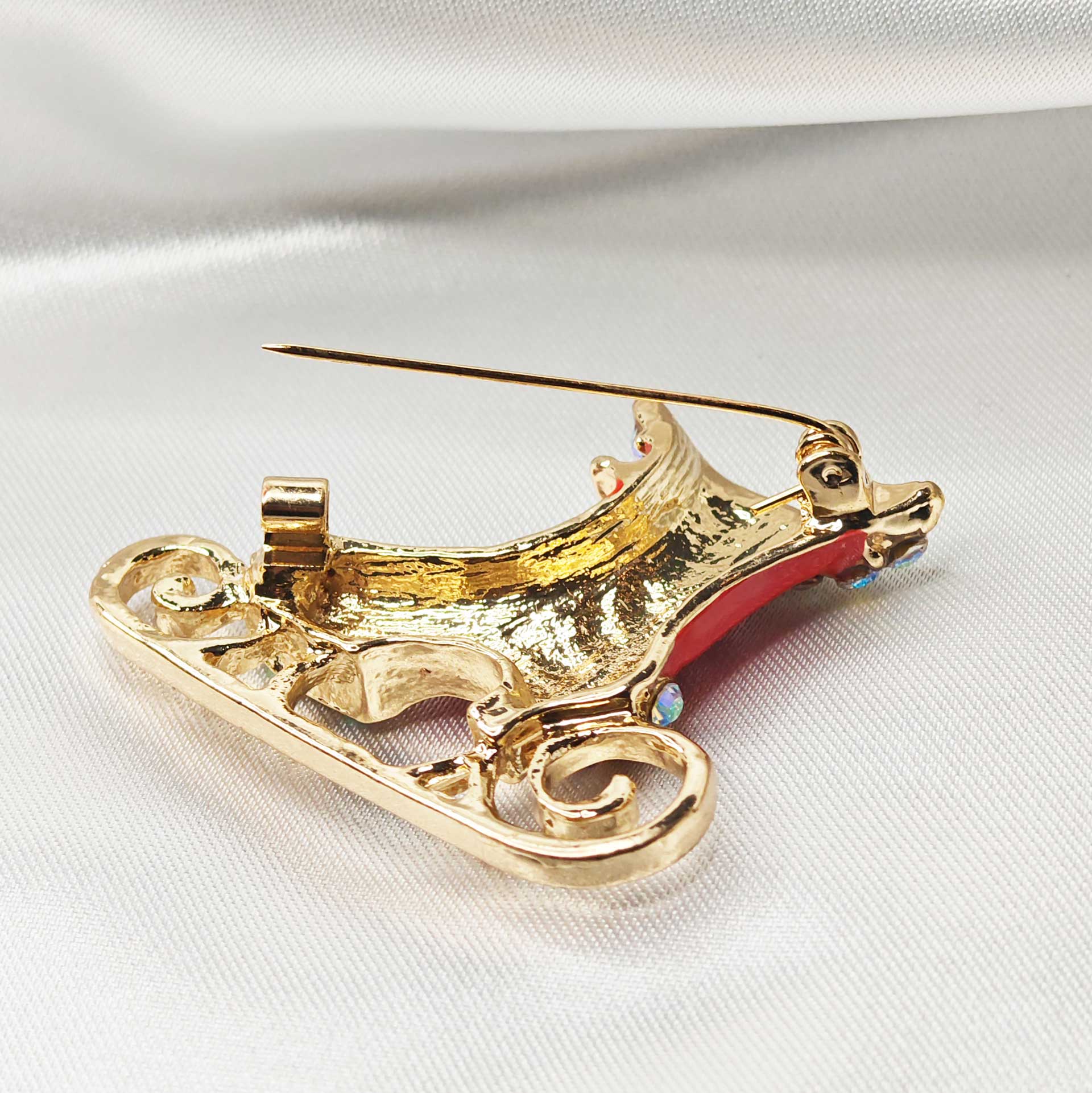 vue zoom de l'attache épingle à nourrice de la broche patin à glace rouge