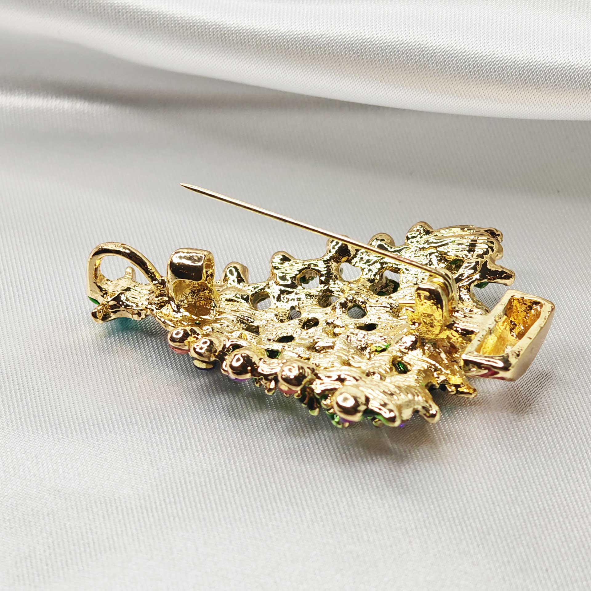 photo zoom sur l'épingle à nourrice de la broche sapin de Noël, on y voit aussi une boucle pour accroche pendentif.