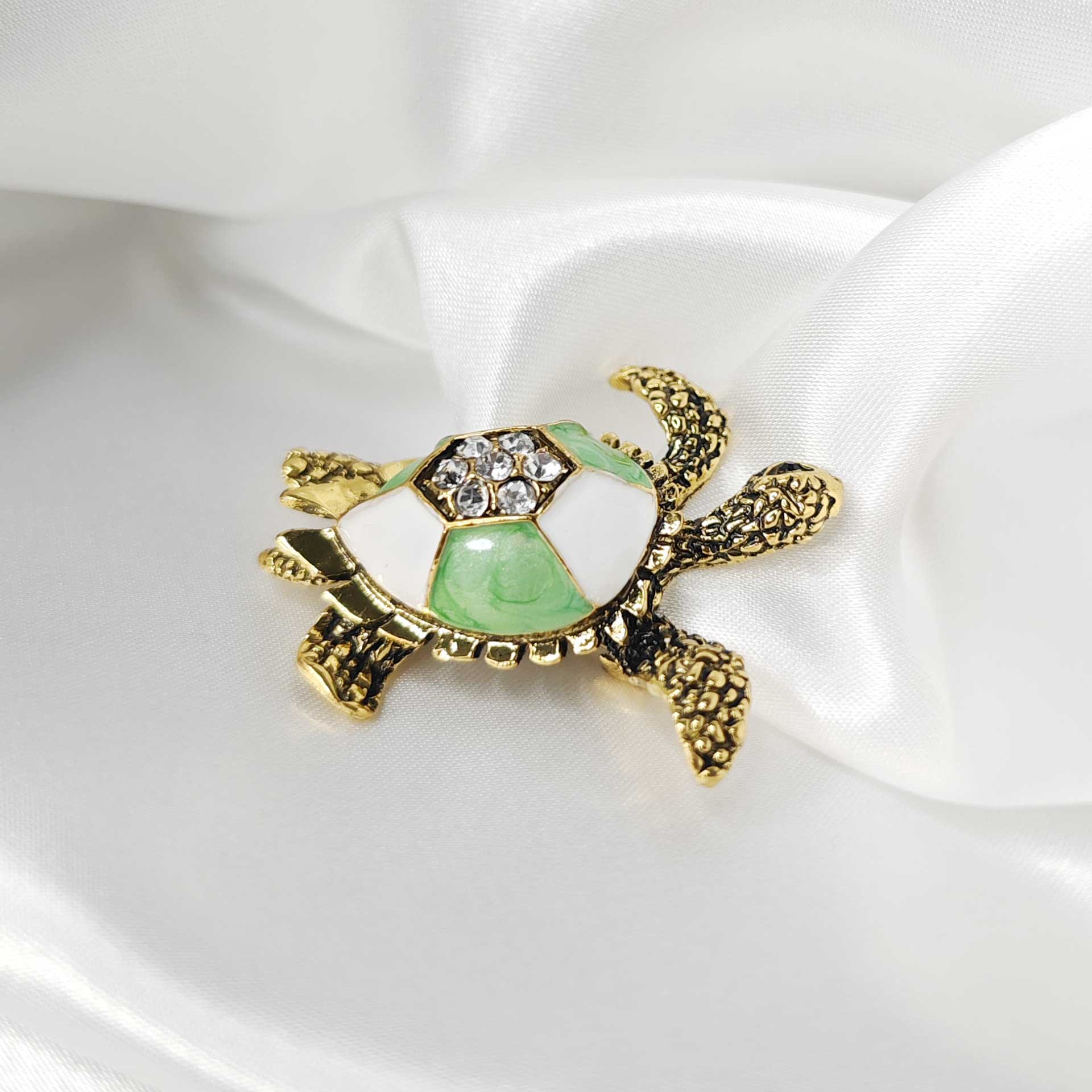 Photo 3 de la broche tortue de mer finition vintage avec une carapace blanche et verte.