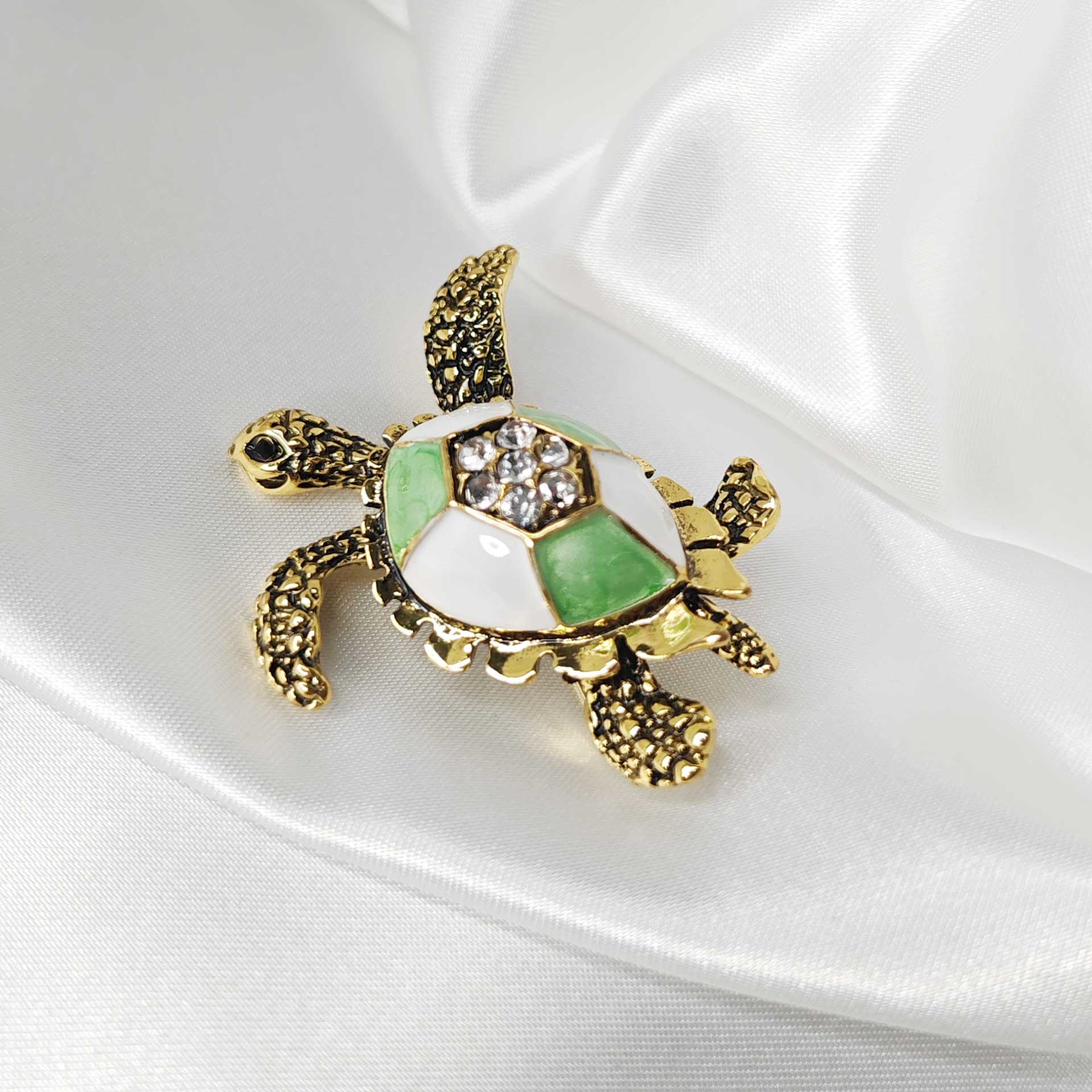 Photo 5 de la broche tortue de mer finition vintage avec une carapace blanche et verte.