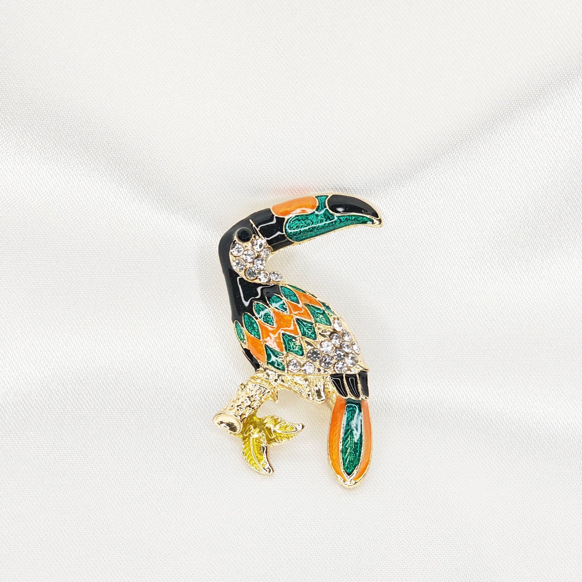 broche dorée toucan émaillé et strass sur branche 