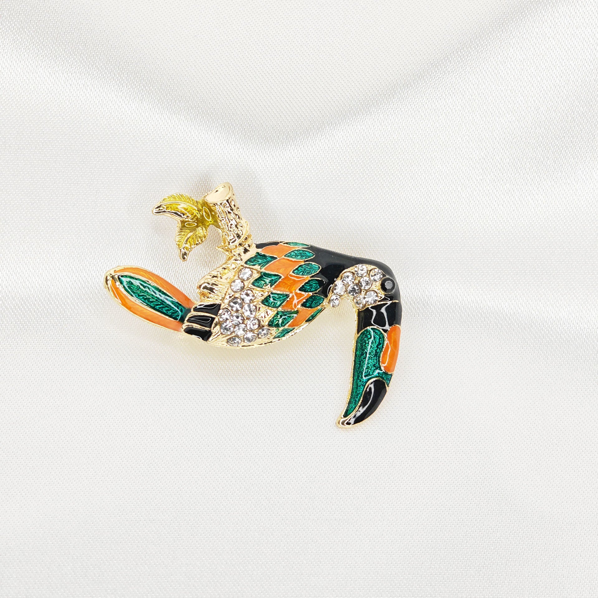 broche dorée toucan émaillé et strass sur branche 