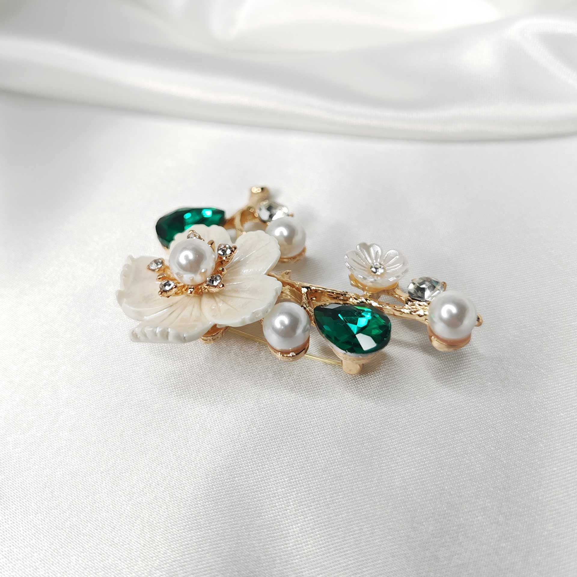 Photo 6 de la Broche fleur de cerisier sakura sur branche ornée de perles et cristaux verts.