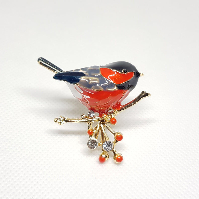 Broche bijou pour femme en forme de rouge gorge portant une branche de cerise avec strass.