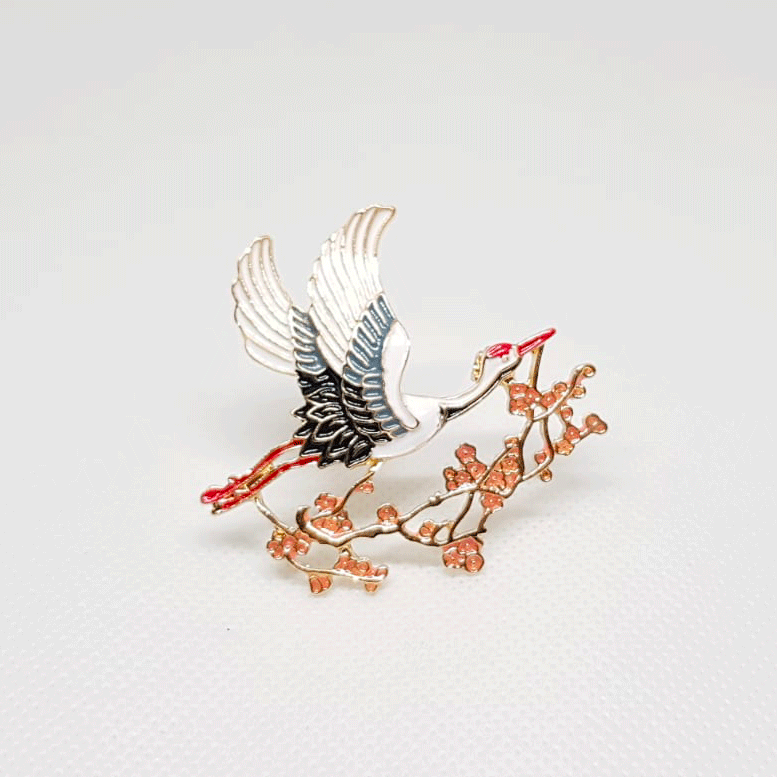 Broche Cigogne sur branche fleurie.