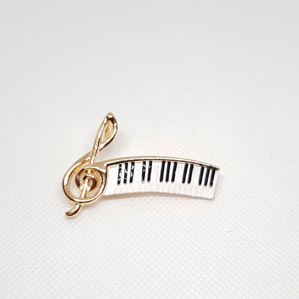 Broche dorée clé de sol et piano.